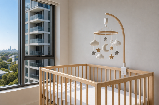 Soft modern Australian apartment nursery with a secure cot mobile above a clear cot