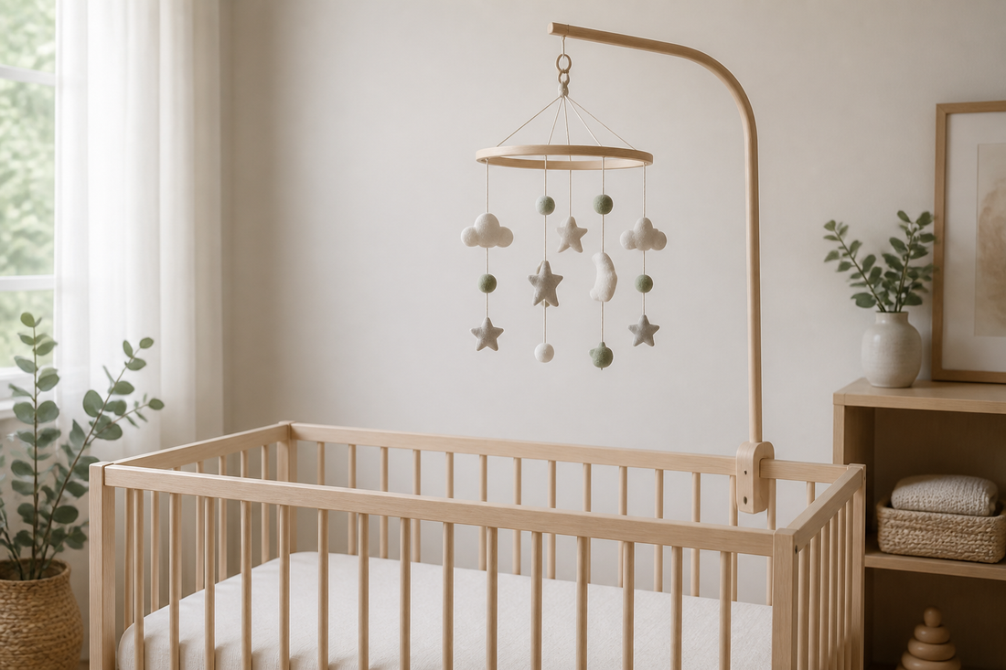 Neutral nursery cot mobile mounted above a clear timber cot